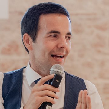 Carlos Villar con micrófono dirigiéndose a una sala